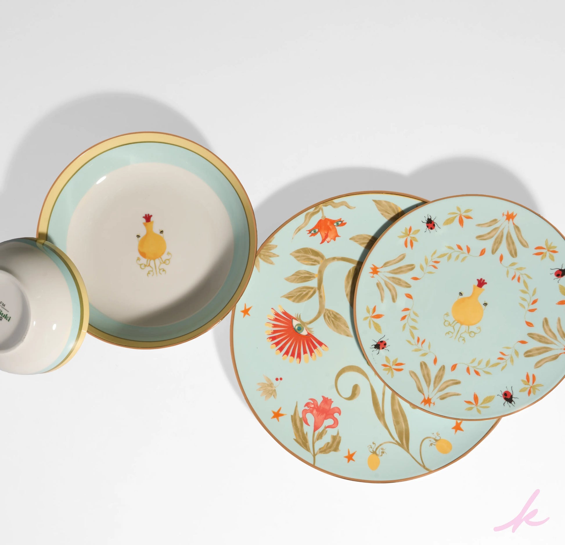 A joyful table setting featuring the Peek-a-Bloom collection, with plates, bowls, and cups adorned with playful flowers and twinkling eyes, perfect for any gathering.